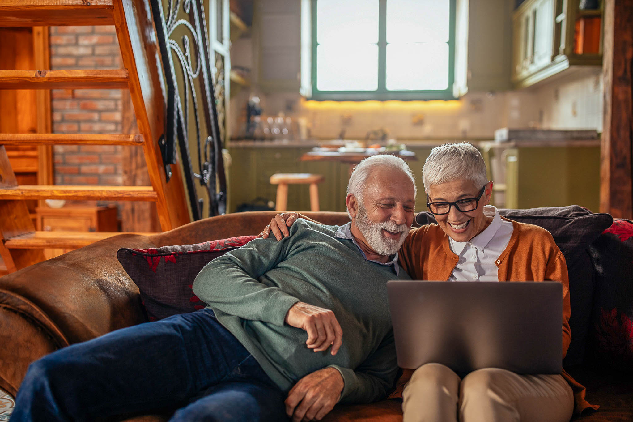 Couple on couch looking at laptop
